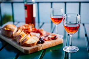 two glasses of wine and italian snacks with amazing view at sunset in italy.