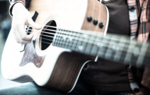 girl holding guitar. focus on strings of guitar